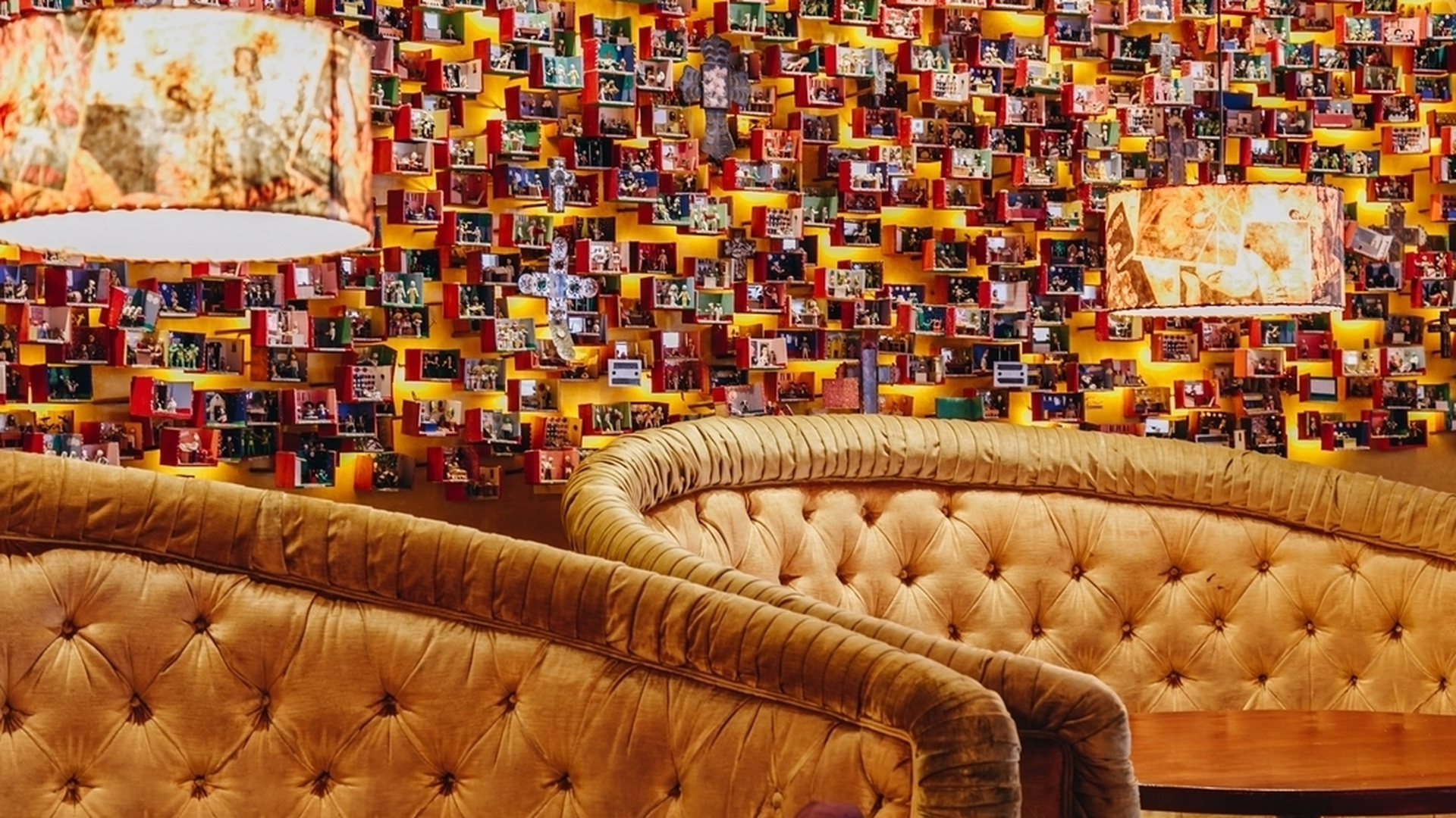 Colorful restaurant interior with patterned booths, red walls, and wooden tables set for dining.